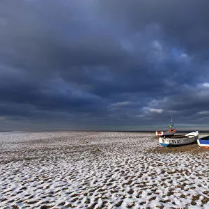Cley Beach with scattering of light snow, and boats, Norfolk, England, UK, December 2010