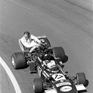 Formula One World Championship: Carlos Pace Frank Williams March 711, gives Ronnie Peterson a lift back to the pits during practice