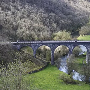 A Bridge With Arches Crossing A Small River In A Valley; Derbyshire, England