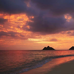Hawaii, Oahu, Kailua, Lanikai, Vibrant sunset with a couple embracing on beach