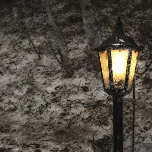 Illuminated Lamp Post Against A Stone Wall; Beamish, England