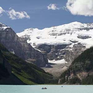 Mount Victoria And Lake Louise With Canoes In The Distance And Blue Sky With Clouds; Lake Louise Alberta Canada