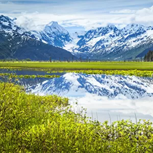Reflection of Chugach Mountains in a tranquil lake in Alaska
