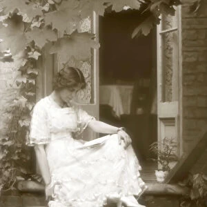 Young woman reading on house step, Victorian or Edwardian era