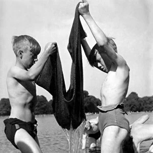 Children fishing with the aid of a sack 5th June 1952. The youngsters drag