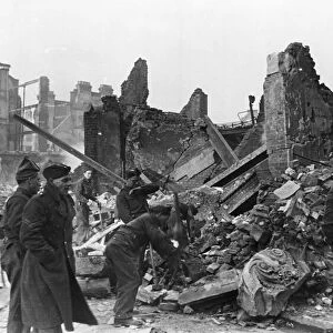 Clearing away rubble at a scene of destruction in London following an air raid during