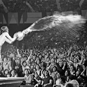 Mick Jagger throwing water over the crowd during a Rolling Stones performance at Earls