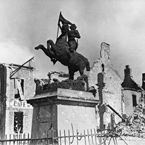 A statue of St Joan of Arc surrounded by ruins in Montebourg during Second World War
