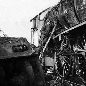 A workman cutting up an old engine at a breakers yard at North Blyth on 5th January 1965