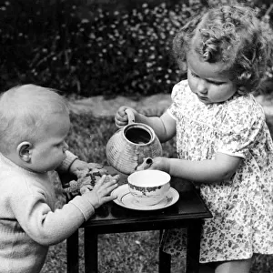 Young girl and boy having tea party. c. 1945 P044477