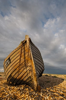 Shore Prints: Abandoned fishing boat on shingle beach, Dungeness, Kent, England, April