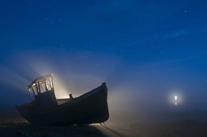 Mists Prints: Abandoned fishing boat on shingle beach at night