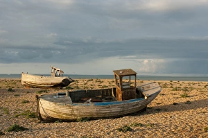 Abandoned fishing boats on shingle beach, Dungeness, Kent, England, April