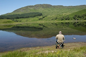 Pastime Prints: Angler sitting on shore of freshwater loch