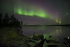 Canoe Prints: Aurora Borealis and stars over lake with beached canoes at night