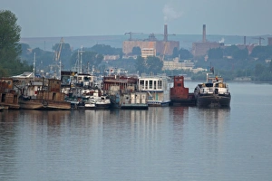Rumania Prints: Barges and tourist pontoon boats moored together on river