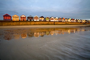 Beach huts on seawall of seaside resort at sunrise, Southwold, Suffolk, England, april