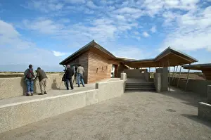 Centres Prints: Birdwatchers standing beside new hides and information centre in coastal wetland reserve