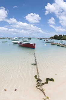Boats moored beside sandy beach, West Mauritius