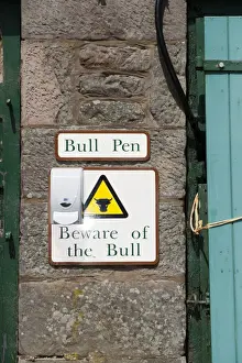 Dangerous Prints: Bull Pen and Beware of the Bull warning signs on wall of farm building, England, May