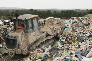 Site Prints: Bulldozer moving rubbish on landfill tip, Dorset, England, February