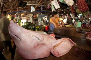 Hogs Prints: Butchers with pig head for sale in indoor market, Siem Riep, Cambodia