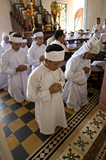 : Caodaist disciples kneeling during ceremony