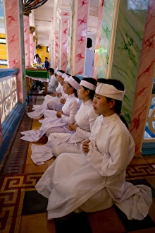 : Caodaist disciples sitting on balcony during ceremony