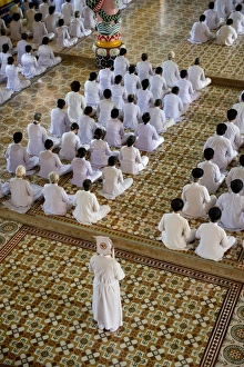 : Caodaist disciples sitting during ceremony