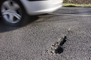 Flood Prints: Car avoiding pothole caused by floods