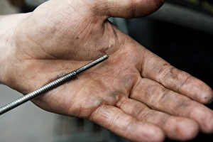 Hand Prints: Checking oil level in tractor engine using dipstick, England, october