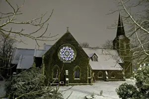 Window Prints: Church in snow at night, with interior lights shining through stained glass window