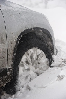 Cars Prints: Close-up of car wheel stuck in snowdrift after snowstorm, Cumbria, England, March