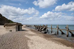 Defence Prints: Coastal defence groynes and upside-down World War Two pillbox on beach