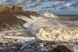 Coastal resort town seafront and lighthouse bombarded by waves, Porthcawl Pier, Porthcawl, Bristol Channel