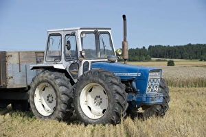 Vehicle Prints: County tractor with trailer, in stubble field at harvest, Sweden, august