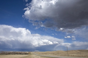 Storm Prints: Cumulus congestus clouds over road through prairie, North Dakota, U. S. A. April