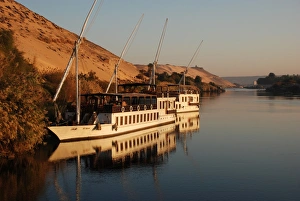 Dahabiya passenger boats moored at riverbank, River Nile, Aswan, Egypt, january
