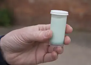 Hand Prints: Dairy farming, milk in National Milk Records sample tube, Cheshire, England, May
