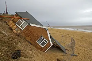 Eroded sea cliffs and damaged chalet after December 2013 tidal surge, Hemsby, Norfolk, England, January