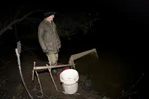 European Eel (Anguilla anguilla) elver fisherman at night, River Severn, Gloucestershire, England, April