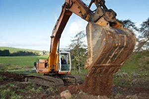 Agriculture Prints: Excavator digging stone on hillside, England, november