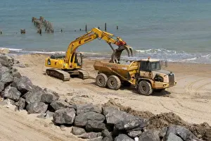 Machinery Prints: Excavator and truck on beach, repairing sea defences with boulders