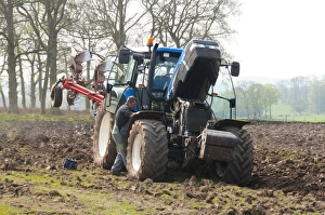 Farmer repairing New Holland tractor with plough in field, Lochmaben, Lockerbie, Dumfries and Galloway, Scotland, april