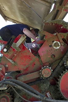 Farmer Prints: Farmer working on round baler, Sweden, june