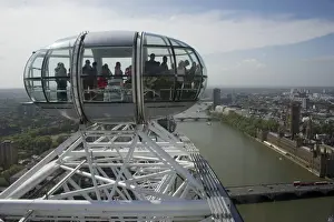 Ferris wheel passenger capsules overlooking city river, London Eye, South Bank, River Thames, Lambeth, London, England