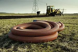 Drain Prints: Field drainage, pipe and continuous pipe laying machine working in arable field