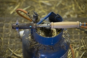 Iron Prints: Gas-powered dehorning iron heating up on dairy farm, Cheshire, England, February