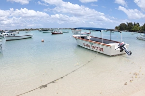 Seawater Prints: Glass Bottom tourist boat moored beside sandy beach, West Mauritius