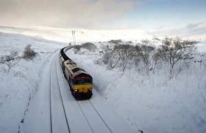 Transports Prints: Goods train carrying load of coal in snow